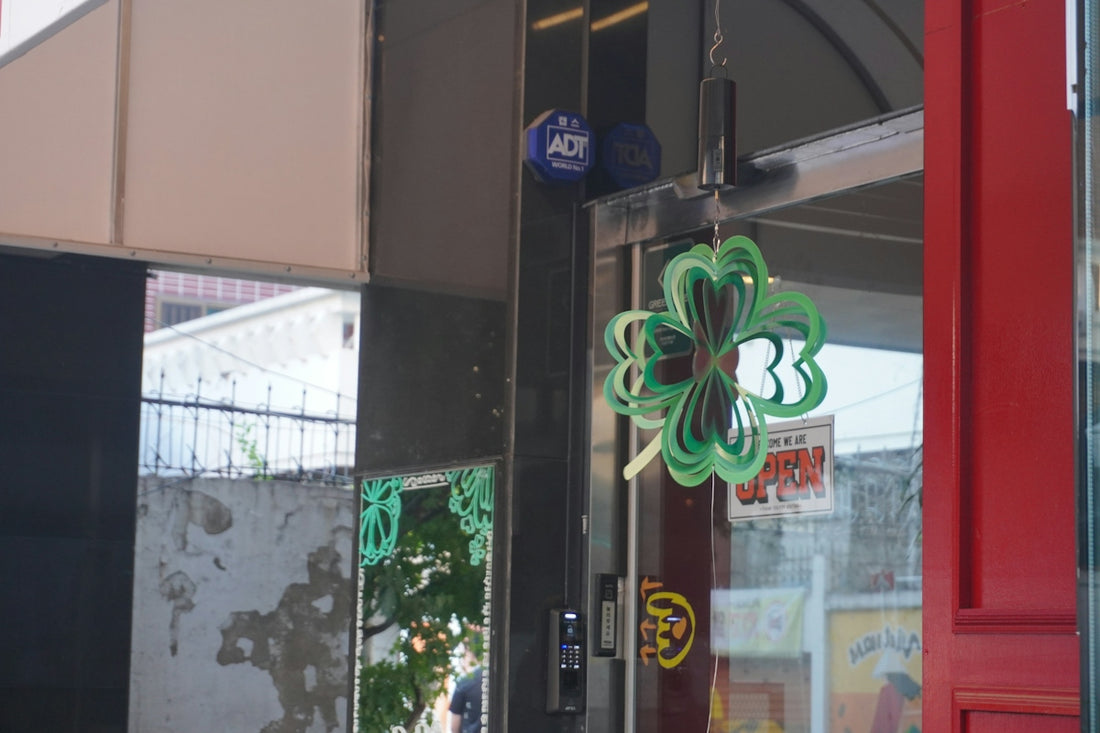 Green four-leaf clover decoration hangs on a glass door